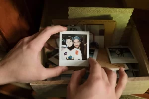 Moving to or from Tcuson AZ. A person holding a Polaroid photo on top of a box with other keepsakes. 